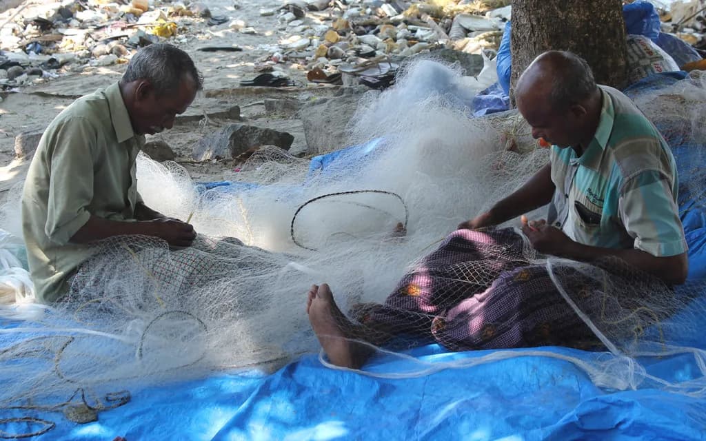 Photo: Fishermen mending nets